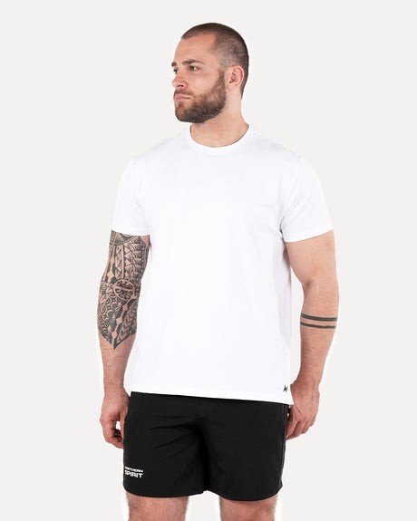 A man wearing a plain white T-shirt and black shorts, standing against a white background.