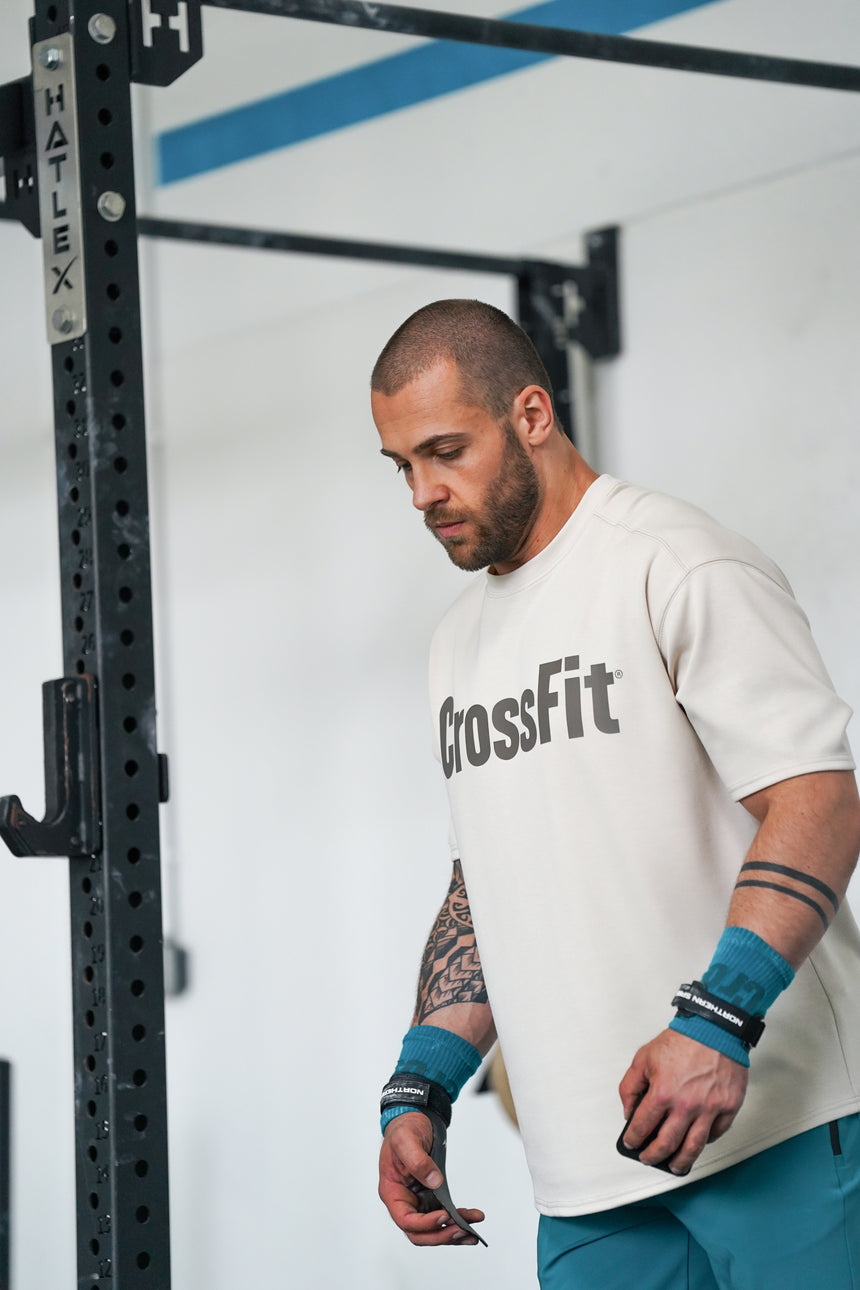 Athlete preparing for training with NS Kraken hand grips secured at the wrist, showing their durable build and comfortable support for high-intensity movements.