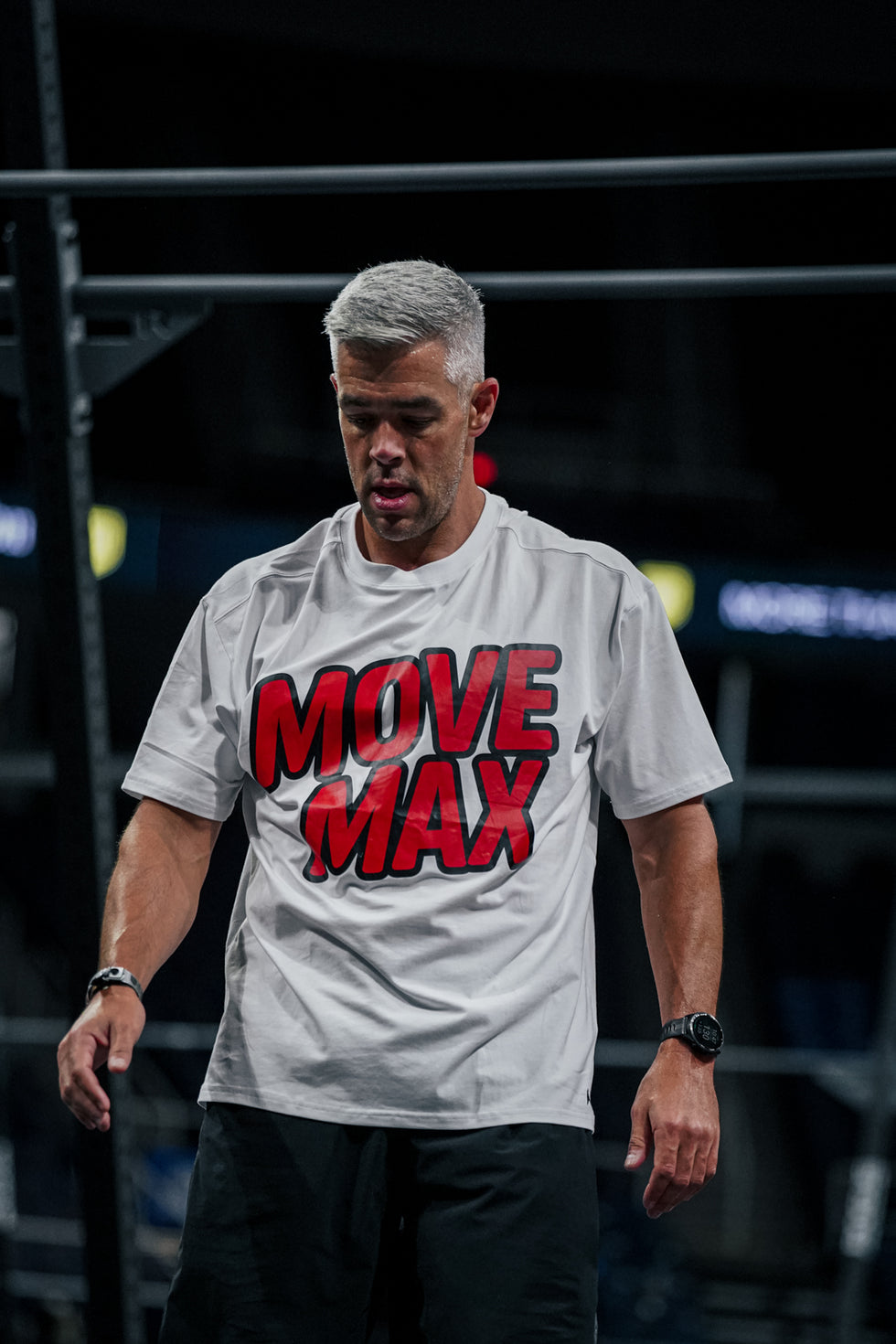 Man wearing a 'MOVE MAX' t-shirt in a dark indoor setting during the CF Games