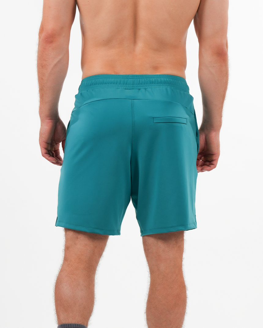 Teal shorts worn by a person on a white background