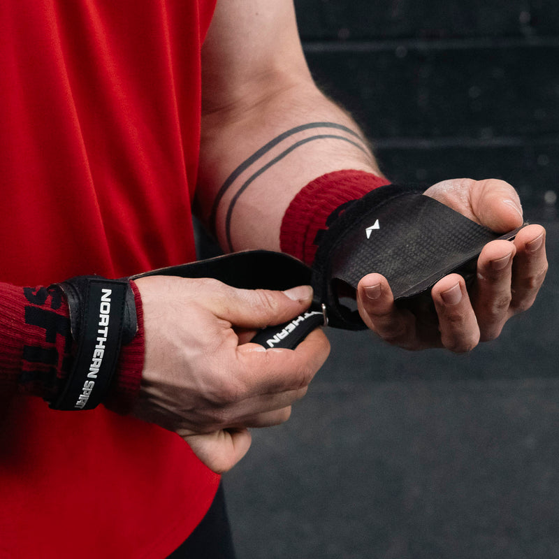 Athlete tightening Northern Spirit grips before training in a CrossFit® gym.