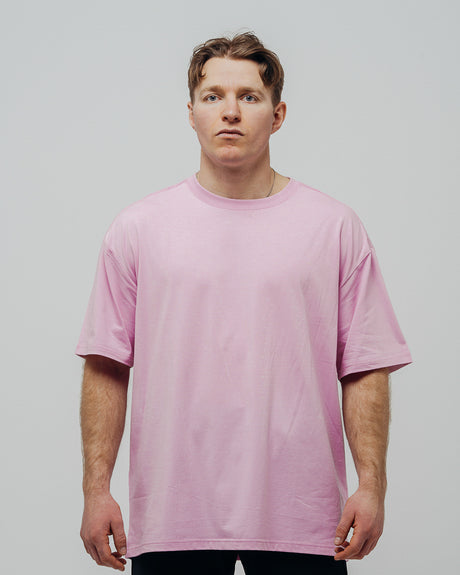 A person wearing a lavender oversized unisex T-shirt.