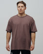 A person wearing a unisex oversized maroon T-shirt.