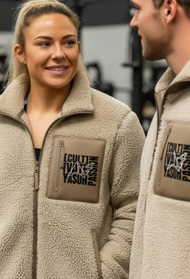 Unisex Cult sherpa jacket worn by athletes, featuring Cultivate Your Passion chest patch in a functional training gym environment