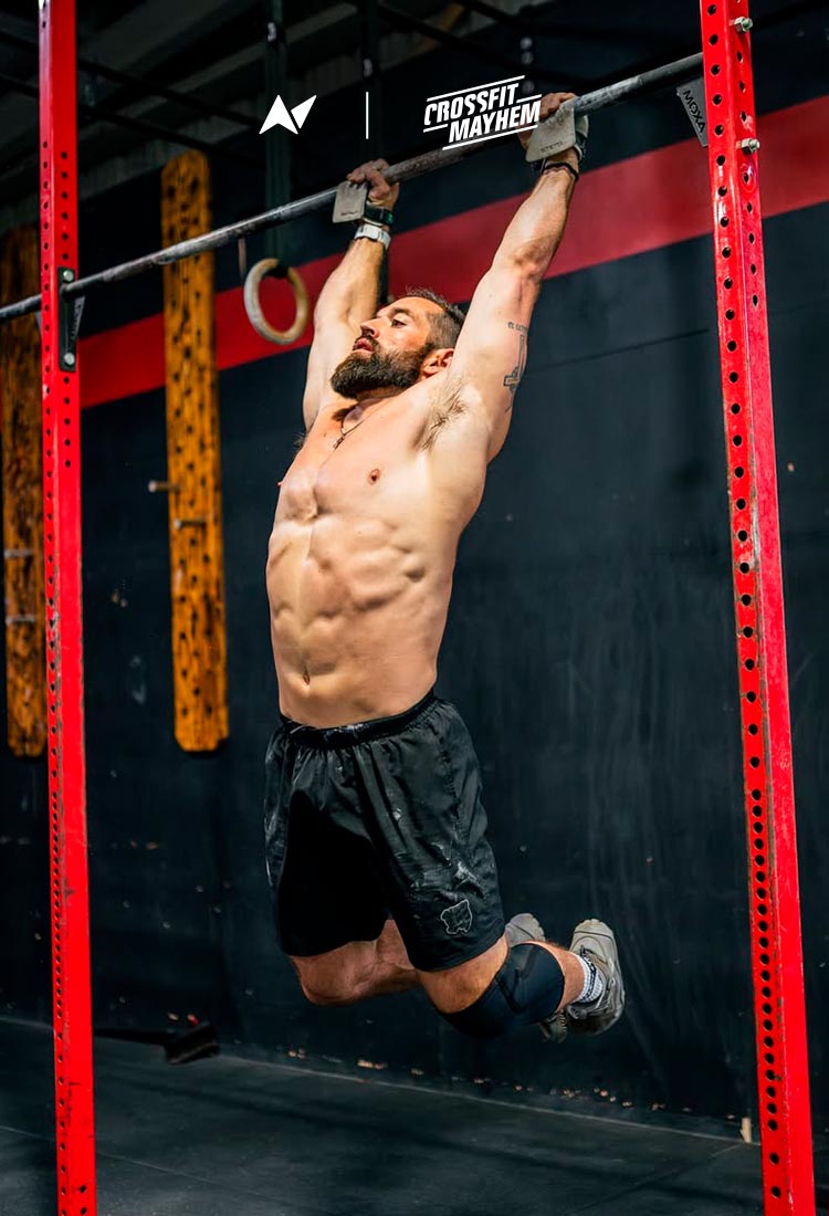 CrossFit® athlete Rich Froning performing pull-ups wearing Northern Spirit x Mayhem Grit Shorts in a functional fitness gym.
