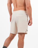 Beige shorts worn by a person on a white background