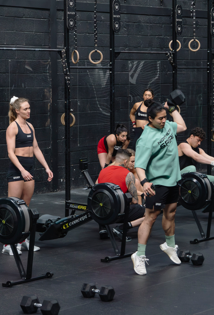 Group of people working out in a gym with weights and fitness equipment.