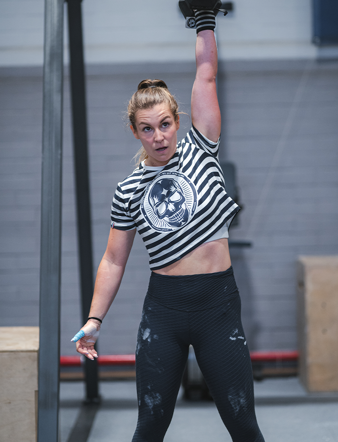 Woman lifting a barbell in a gym setting