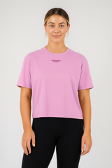 Person wearing a pink t-shirt with a logo on a white background