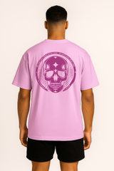 Person wearing a pink t-shirt with a purple skull design on the back against a white background