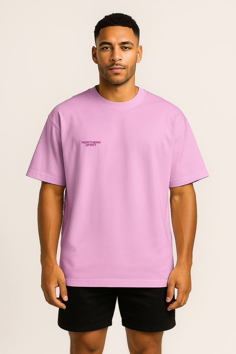 Person wearing a light purple t-shirt with a small logo on a beige background