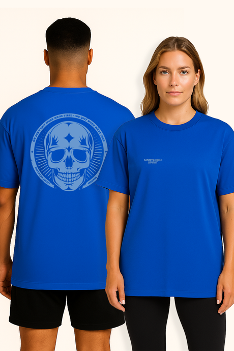 Man and woman wearing matching blue Northern Spirit T-shirts with skull print on the back.
