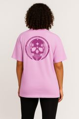 Person wearing a pink t-shirt with a purple skull design on the back against a plain background