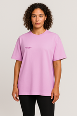 Person wearing a pink t-shirt with a logo on a plain background